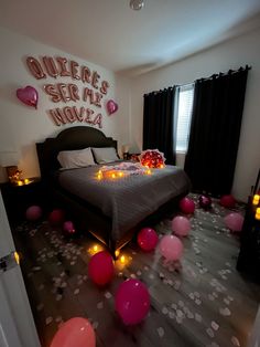 a bedroom decorated with balloons and confetti on the floor for valentine's day