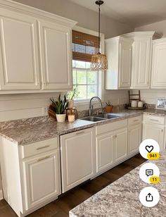 an image of a kitchen setting with white cabinets and granite counter tops on the island