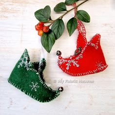 two ornaments are sitting on a table next to each other, one is red and the other is green