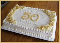 a 50th birthday cake with white frosting and yellow roses