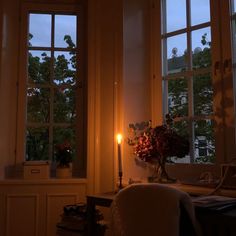 a room with two windows and a candle in the corner