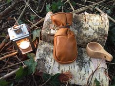 a brown glove sitting on top of a tree stump next to a light