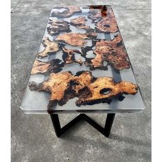 a glass table with wood pieces on it in the middle of concrete flooring area