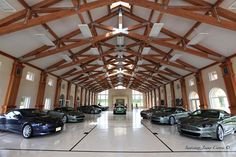 a large room filled with lots of cars in front of a wooden ceiling and windows