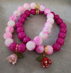 Two beautiful bracelets, 10MM glass beads with cute flowers charms. Pink Bracelets With Flower Charm And Round Beads, Pink Flower-shaped Stretch Bracelet Gift, Pink Flower Stretch Bracelet Gift, Pink Beaded Flower Charm Bracelet, Pink Flower-shaped Stretch Bracelet With Colorful Beads, Pink Flower-shaped Beaded Charm Bracelet, Flower Charm Bracelet With Round Beads, Flower-shaped Heart Beads Bracelets For Gifts, Flower Shaped Bracelets With Heart Beads For Gifts