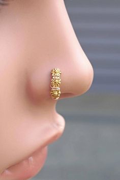 a woman's nose with a gold earring on it