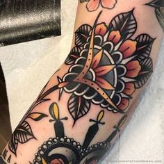 a woman's arm with a clock and flowers tattoo on her left arm,