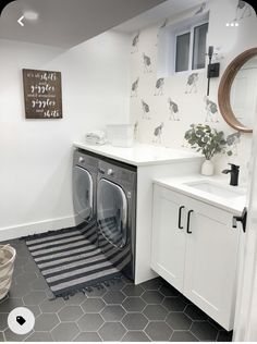 a washer and dryer in a bathroom with grey floor tiles on the walls