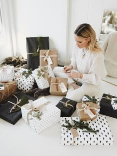 a woman sitting on the floor surrounded by presents