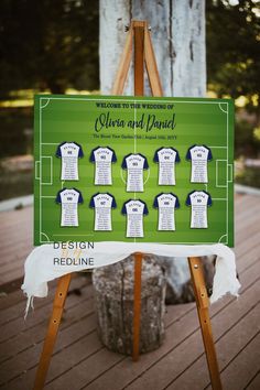 a green and white wedding seating chart on a easel next to a wooden tree