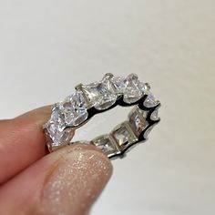 a hand holding a diamond ring in it's palm