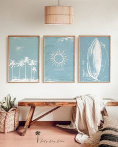 three framed pictures hang on the wall above a wooden bench in a room with wicker baskets