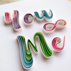 the letters made out of colored paper are arranged in different shapes and sizes on a white surface