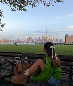 a woman sitting on top of a wooden bench