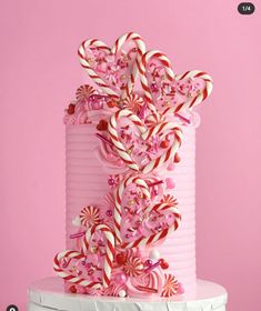 a pink cake decorated with candy canes and candies