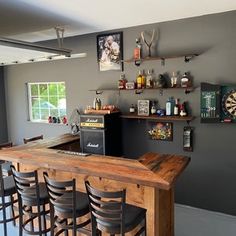 a bar with several stools in front of it and pictures on the wall behind it