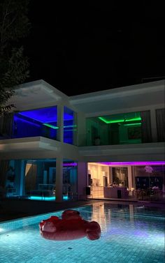 an illuminated pool in front of a house at night