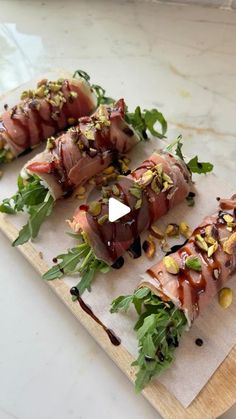 four sushi rolls on a cutting board with sauce drizzled over them