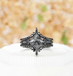 a black diamond ring sitting on top of a white cloth