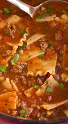 a red bowl filled with pasta and meat soup