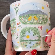 a woman is holding a coffee mug with an image of a bird and flowers on it