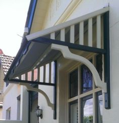 an open window on the side of a building with black and white trimmings