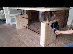 a man is working on a table made out of plywood and metal bars with wheels