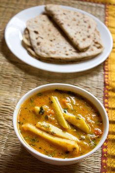 a bowl of soup with pita bread on the side