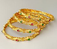 Indian gold replica bangles with ruby and green stone details. This beautiful gold finish Brass bangles comes in set of 4. ❤️Free USPS priority mail on all order $50 and above in USA❤️  All orders Ship same day if placed before 4:00 PM EST  Create beautiful memory for any occasion with elegant jewelry for your loved ones We will be happy to navigate you through the process so if you have any questions regarding our product before placing an order reach out to us and we will be there to help you. Gold Jeweled Bangle For Celebration, Traditional Jeweled Yellow Gold Bangle, Traditional Yellow Gold Jeweled Bangle, Green Bangle With Intricate Design For Diwali, Traditional Gold Plated Bangle For Celebrations, Gold Jeweled Bangle For Festivals, Ceremonial Green Bangle With Intricate Design, Traditional Yellow Gold Bangle For Celebration, Green Temple Jewelry Bangle For Festive Occasions