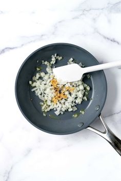 onions and spices in a pan with a spoon