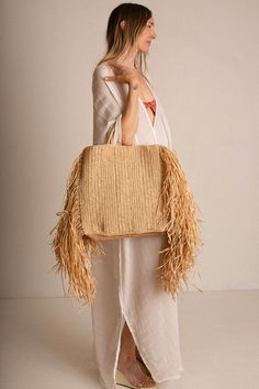 Raffina tote with woven handles, and 12" draped fringe at sides. Tote measures 14.5" wide (without fringe), 16" tall and 4" in depth. Handcrafted in France. Chic Fringe Tote Shoulder Bag, Chic Tote Shoulder Bag With Fringe, Chic Rectangular Fringe Shoulder Bag, Chic Beige Fringe Shoulder Bag, Bohemian Shoulder Bag With Fringe, Bohemian Fringe Shoulder Bag For Shopping, Spring Beige Shoulder Bag With Fringe, Shopping Tote Bag With Fringe, Beige Fringe Shoulder Bag For Spring