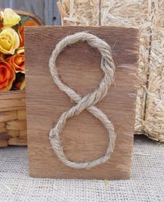 a wooden block with the number eight on it and some flowers in a basket behind it