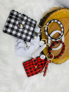 several purses and keychains laying on top of a white furnishing