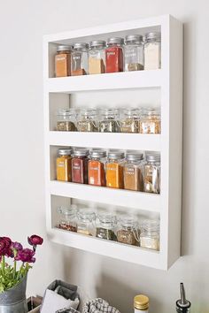 a wall mounted spice rack with jars and spices