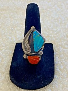 This beautiful vintage ring has a turquoise and a red coral stone, as well as a silver leaf and raindrops design. The turquoise has some carvings that mimics a butterflies wing. Unmarked but tested sterling silver. Very good vintage condition. It is 1.25" long and .9" wide. SIZE: 6.75 WEIGHT 6.94 grams - Please note, most of my store's items are vintage or pre-owned. Most items are in very good/good vintage pre-owned condition. - Thank you so much for shopping with me and please check out my oth Southwestern Style Red Turquoise Ring, Red Coral Stone, Beautiful Rings Vintage, Grants Pass, Coral Stone, Bon Bon, Vintage Navajo, Coral Turquoise, Multi Stone Ring