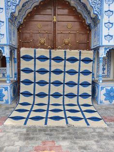 a blue and white area rug in front of a wooden door