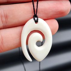 Natural Hand Carved Maori Bone Carving Pendant Necklace - Koru Spiral  Description: Stunning natural Kiwi Maori bone carving necklace, Koru Spiral  Strung on black cord with two lose ends to tie yourself - on request we can add sliding knots for no extra charge.  Please note: This product is listed on other platforms and there is a slight chance it could sell before we get time to take it off this platform - we will message alternatives or offer a refund in such event.  Please note, generic phot Unique Carved White Necklace, Maori Pendant, Spiritual Carved Round Pendant Necklace, Carved Wood Necklace Pendants, Carved Bone Pendant, Bone Pendant, Sliding Knot, Diy Wire Jewelry, Bone Carving