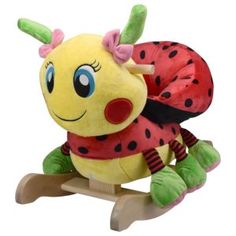 a stuffed animal sitting on top of a wooden rocking toy with a ladybug design