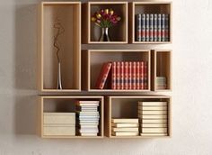 there is a book shelf with many books on it and a vase filled with flowers