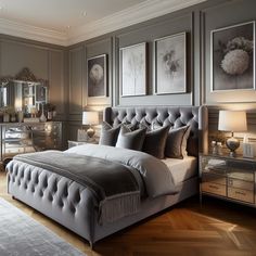 a bedroom with gray walls and pictures on the wall above the bed, along with mirrored nightstands