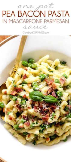 pasta with bacon and asparagus in a white bowl on top of a wooden table