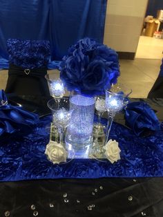 a table topped with blue flowers and candles