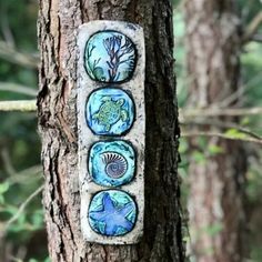 three sea creatures are painted on the bark of a tree