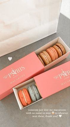 two pink boxes with macaroons in them