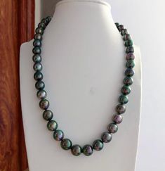 Stunning Tahitian Peacock Pearl Beaded Necklace, 8-10mm, Vivid Green color, Multi-colored Pearls, Very High luster. Perfect size for daily wear.   Classic and Elegant   Lustrous Beauty  Pearl ★ Pearl: Genuine Tahitian pearl, Saltwater  ★ Quality: AA+/AAA ★ Size: 8mm - 10mm ★ Color: Natural Untreated, Vivid Peacock / Intense Green/Multi-colored ★ Shape: Round /Near Round ★ Luster: Very High luster, Wonderful ★ Body:  Nice, Baby Smooth and Mirror Like, Mostly clean (85 with Natural Marks, not visible when wear ★ Necklace Length: 42.5cm/16.7inches Accessories ★ Metal: Sterling Silver Clasp, Easy to use  Shipping FREE with USPS First Class in US Green Single Strand Pearl Necklace, Tahitian Pearl Necklace With Round Beads, Single Strand Green Pearl Necklace, Green Single Strand Pearl Necklace With Round Beads, Colored Pearls, Nice Baby, Peacock Pearl, Pearl Beaded Necklace, Wear Necklaces