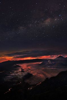 the night sky is filled with stars and clouds, as seen from an overlook point