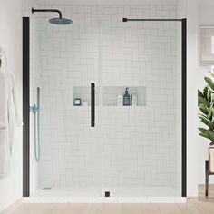 a white tiled bathroom with black trim and glass shower doors