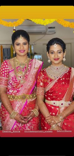 two women dressed in red and gold posing for the camera with their hands on their hips