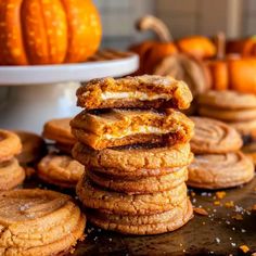 several cookies stacked on top of each other with pumpkins in the background