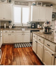 a kitchen with wooden floors and white cabinets